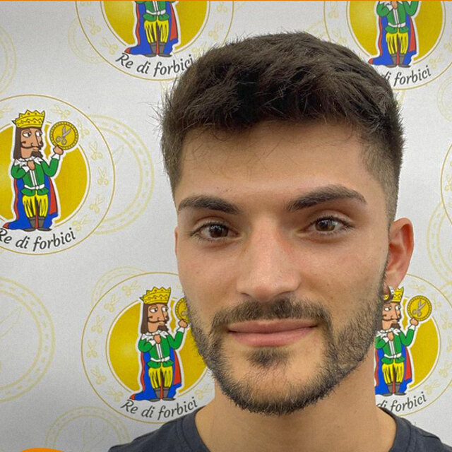 Ritratto di Francesco davanti alla parete coi loghi del negozio