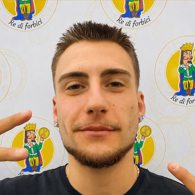 Ritratto di Riccardo davanti alla parete coi loghi del negozio